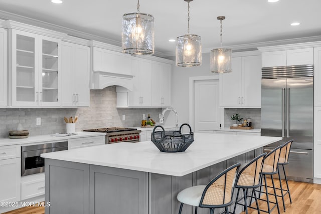 516 13th Ave, Belmar, NJ 07719 - kitchen featuring appliances with stainless steel finishes, decorative backsplash, light countertops, a breakfast bar, and white cabinets