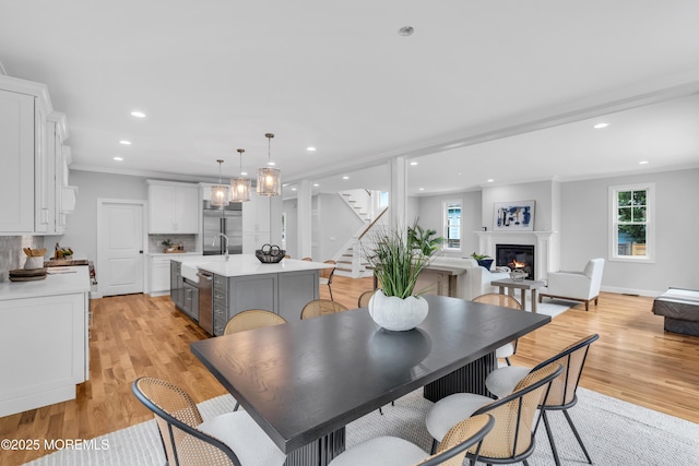 516 13th Ave, Belmar, NJ 07719 - dining area featuring stairs, light wood finished floors, a glass covered fireplace, healthy amount of natural light, and recessed lighting