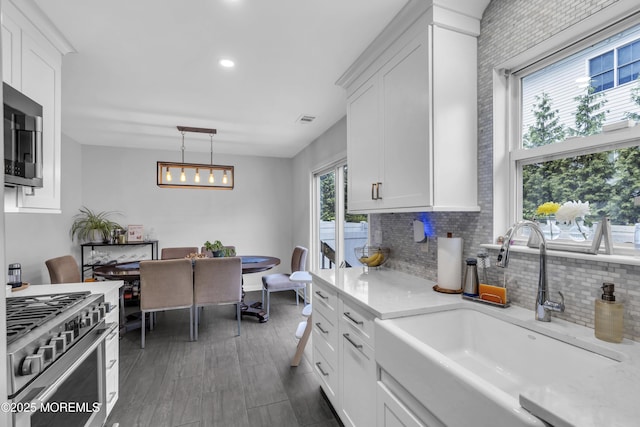 108 Drs James Parker Blvd Unit D8, Red Bank, NJ 07701 - kitchen featuring appliances with stainless steel finishes, a sink, light countertops, white cabinetry, and decorative backsplash