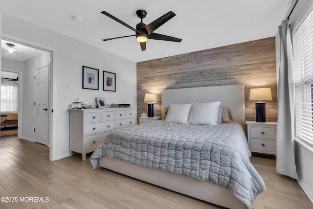 108 Drs James Parker Blvd Unit D8, Red Bank, NJ 07701 - bedroom with an accent wall, baseboards, light wood-style floors, wood walls, and a ceiling fan