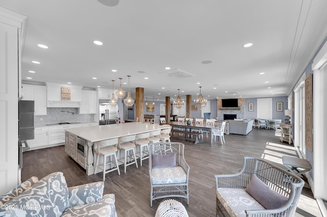 1055 Ocean Ave, Mantoloking, NJ 08738 - living area with a fireplace, dark wood-type flooring, recessed lighting, and a chandelier