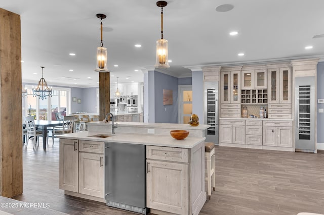 1055 Ocean Ave, Mantoloking, NJ 08738 - kitchen with ornamental molding, a sink, light countertops, a kitchen island with sink, and light wood finished floors