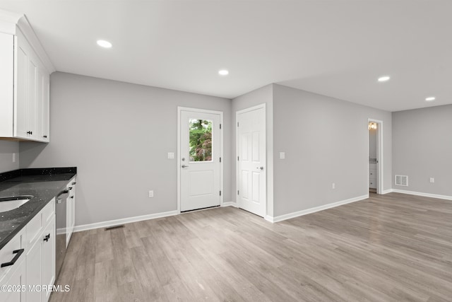 53 Burnt Tavern Rd, Brick, NJ 08724 - kitchen with dark stone counters, light wood-style floors, white cabinetry, dishwasher, and baseboards