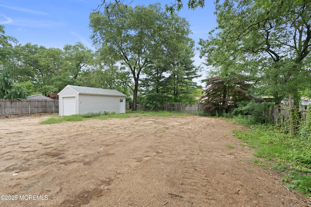 53 Burnt Tavern Rd, Brick, NJ 08724 - view of yard with an outdoor structure, a garage, and view of wooded area