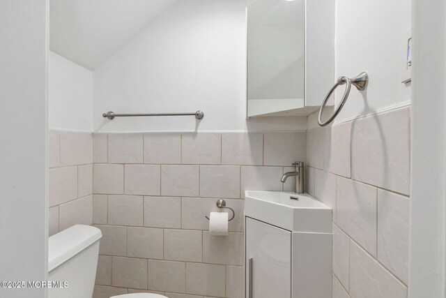 29 Grand Ave, Atlantic Highlands, NJ 07716 - half bathroom with tile walls, toilet, vanity, and lofted ceiling