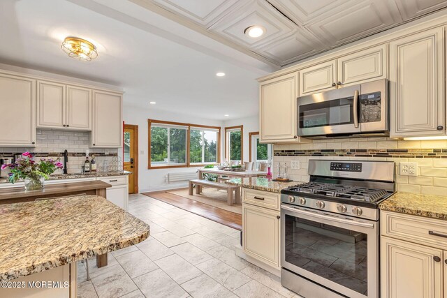 29 Grand Ave, Atlantic Highlands, NJ 07716 - kitchen with cream cabinets, appliances with stainless steel finishes, tasteful backsplash, recessed lighting, and light stone counters
