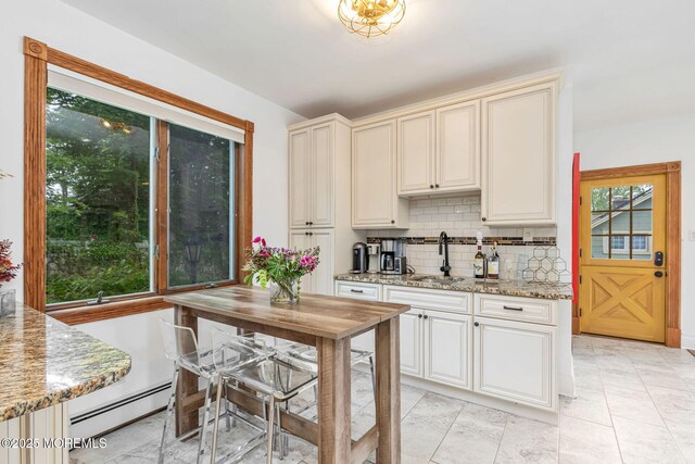 29 Grand Ave, Atlantic Highlands, NJ 07716 - kitchen with a baseboard radiator, a sink, decorative backsplash, light stone counters, and cream cabinetry