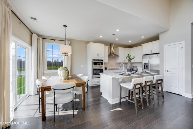 10 Prado Rd, Monroe, NJ 08831 - kitchen featuring stainless steel appliances, wall chimney range hood, dark wood-style flooring, a breakfast bar area, and recessed lighting