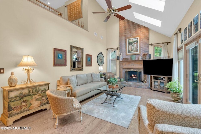 203 Stone Hill Rd, Freehold, NJ 07728 - living room featuring high vaulted ceiling, wood finished floors, a skylight, ceiling fan, and a brick fireplace