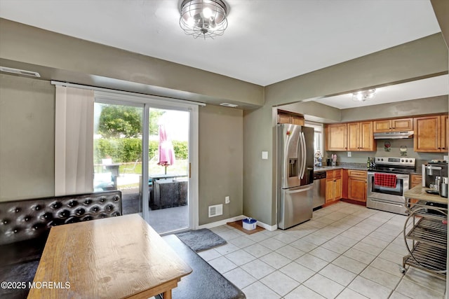 15 Transom Ln, Barnegat, NJ 08005 - kitchen with stainless steel appliances, under cabinet range hood, light tile patterned floors, baseboards, and brown cabinetry