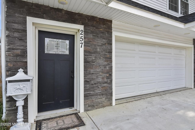 257 Port Monmouth Rd, North Middletown, NJ 07748 - property entrance featuring stone siding, a shingled roof, and concrete driveway