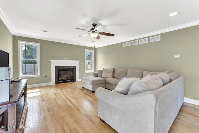 531 Parker Ave, Brick, NJ 08724 - living room with ornamental molding, a ceiling fan, baseboards, light wood-type flooring, and a glass covered fireplace