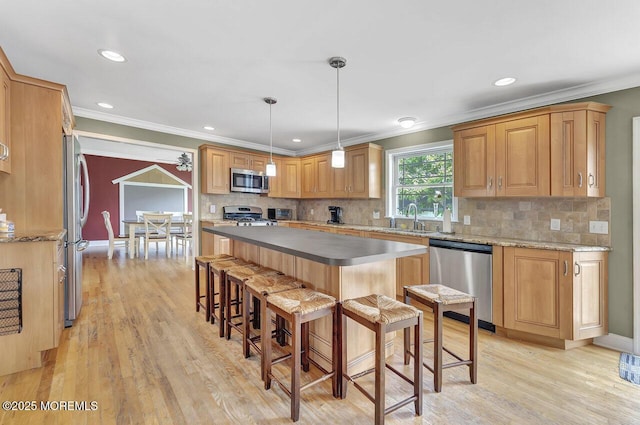 531 Parker Ave, Brick, NJ 08724 - kitchen featuring appliances with stainless steel finishes, ornamental molding, a sink, a breakfast bar area, and light wood-style floors