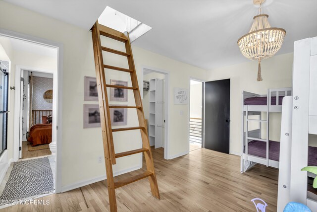 1213 Ariel Dr, Forked River, NJ 08731 - hallway with light wood-style floors, a chandelier, baseboards, and a skylight