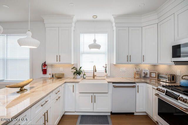 53 Blaine, Seaside Heights, NJ 08751 - kitchen with appliances with stainless steel finishes, a sink, white cabinets, tasteful backsplash, and light stone counters