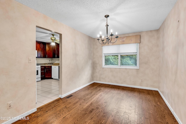 20 Lone Star Ln, Manalapan, NJ 07726 - unfurnished dining area with a chandelier, light wood-type flooring, a textured ceiling, and baseboards