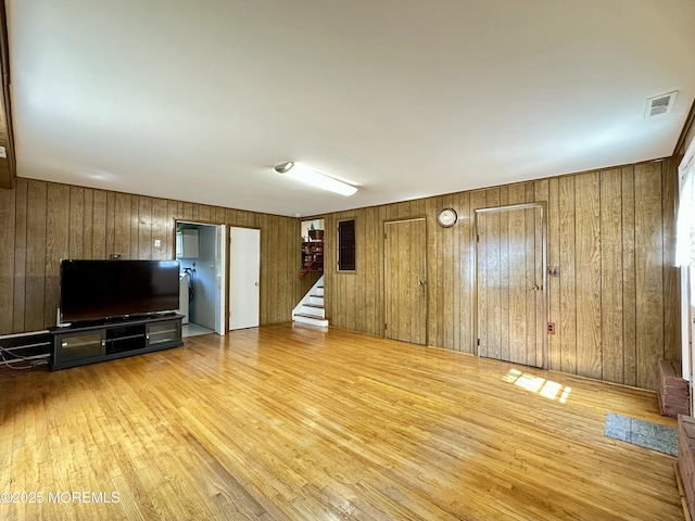 404 Harmony Rd, Middletown, NJ 07748 - unfurnished living room featuring wood finished floors, wooden walls, and stairway