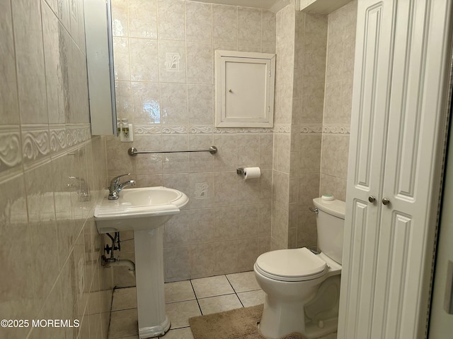 404 Harmony Rd, Middletown, NJ 07748 - bathroom featuring tile patterned floors, toilet, tile walls, and a sink