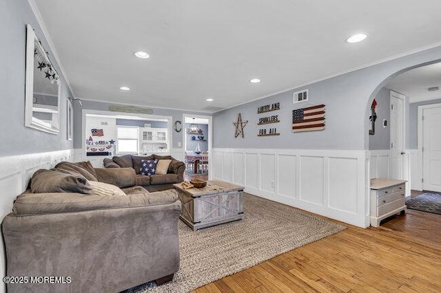 2909 Arthur St, Wall, NJ 07719 - living room featuring arched walkways, wainscoting, crown molding, wood finished floors, and recessed lighting