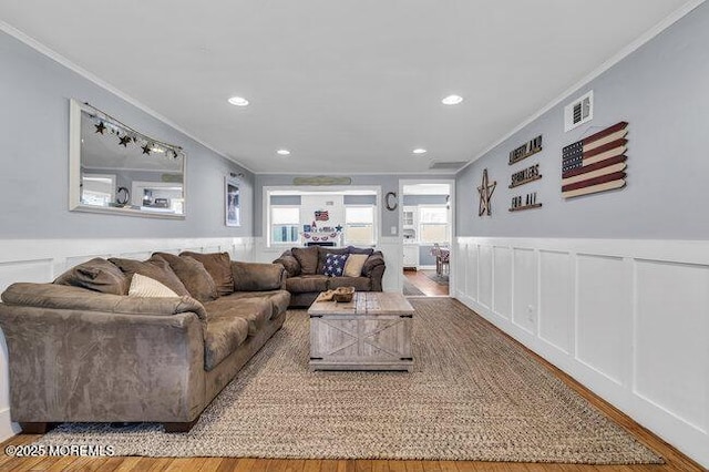 2909 Arthur St, Wall, NJ 07719 - living area with crown molding, a decorative wall, wood finished floors, a wainscoted wall, and recessed lighting