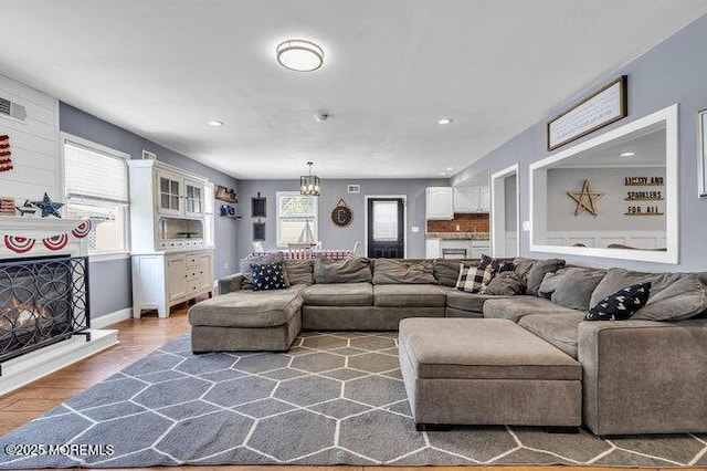 2909 Arthur St, Wall, NJ 07719 - living room featuring wood finished floors, a chandelier, recessed lighting, and a lit fireplace