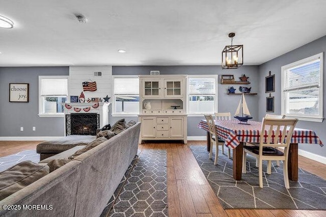 2909 Arthur St, Wall, NJ 07719 - dining room featuring dark wood finished floors, healthy amount of natural light, a chandelier, a fireplace, and recessed lighting