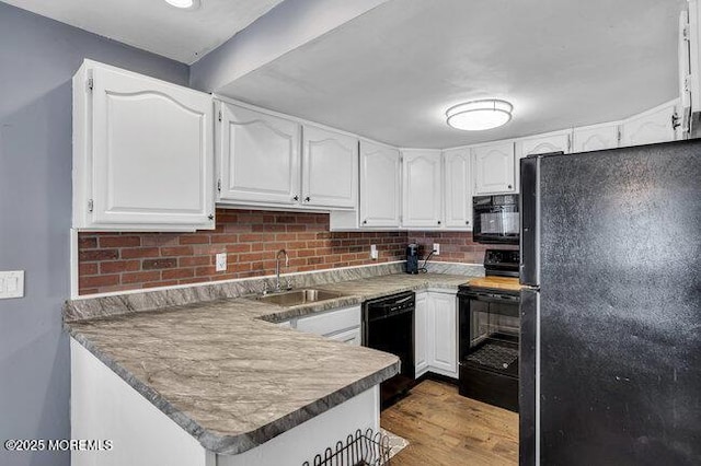 2909 Arthur St, Wall, NJ 07719 - kitchen featuring black appliances, a peninsula, white cabinets, and backsplash