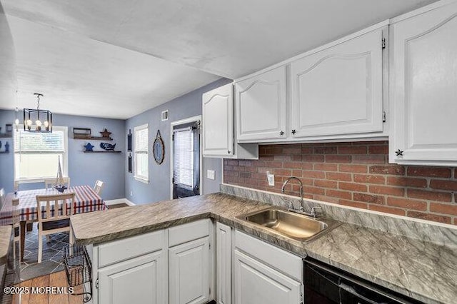 2909 Arthur St, Wall, NJ 07719 - kitchen with black dishwasher, a peninsula, a chandelier, white cabinets, and tasteful backsplash