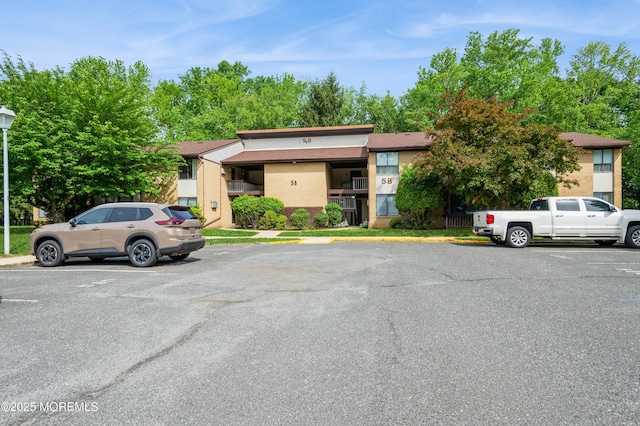 58 Amberly Dr Unit E, Manalapan, NJ 07726 - view of front of property with uncovered parking and stucco siding