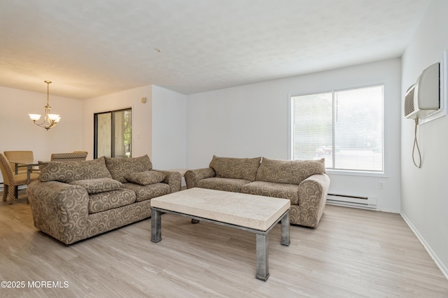 58 Amberly Dr Unit E, Manalapan, NJ 07726 - living area featuring a baseboard radiator, a chandelier, light wood-style flooring, and a wall mounted air conditioner