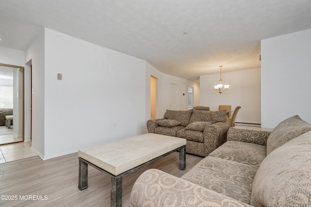 58 Amberly Dr Unit E, Manalapan, NJ 07726 - living area with a chandelier, baseboard heating, light wood-style floors, and baseboards