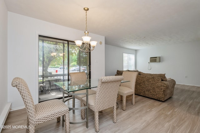 58 Amberly Dr Unit E, Manalapan, NJ 07726 - dining space with a chandelier, light wood-style flooring, a wall mounted AC, and baseboards