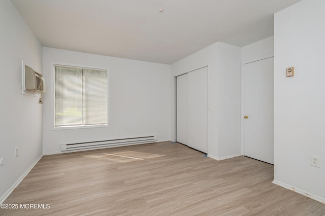 58 Amberly Dr Unit E, Manalapan, NJ 07726 - unfurnished bedroom with a baseboard radiator, light wood-style floors, baseboards, and a closet