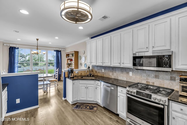 66 Shore Dr Unit 20, South Amboy, NJ 08879 - kitchen with appliances with stainless steel finishes, a chandelier, a sink, ornamental molding, and white cabinetry