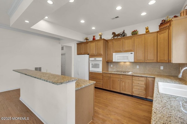 39 Barton Creek Rd, Jackson, NJ 08527 - kitchen with white appliances, light wood finished floors, decorative backsplash, light stone counters, and a kitchen island