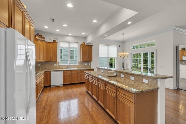 39 Barton Creek Rd, Jackson, NJ 08527 - kitchen with white appliances, a chandelier, light wood-style floors, backsplash, and a large island