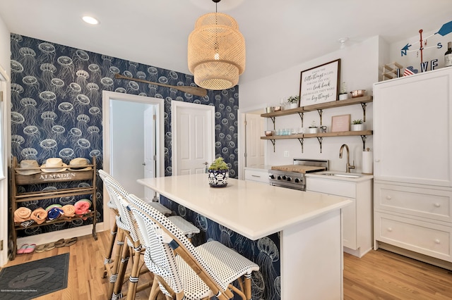 142 Heck Ave, Ocean Grove, NJ 07756 - kitchen featuring wallpapered walls, a sink, white cabinetry, light wood-type flooring, and light countertops