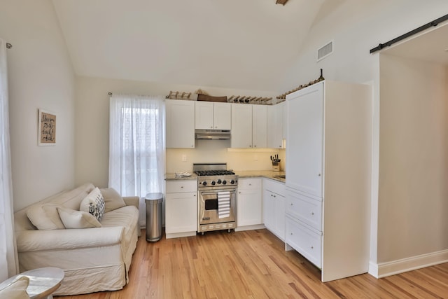 142 Heck Ave, Ocean Grove, NJ 07756 - kitchen with stainless steel stove, a barn door, light wood finished floors, white cabinetry, and under cabinet range hood