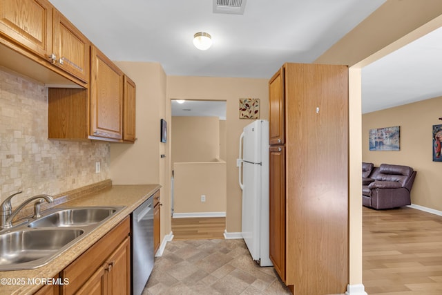 7 Juniper Ln, Jackson, NJ 08527 - kitchen with freestanding refrigerator, stainless steel dishwasher, a sink, decorative backsplash, and light countertops