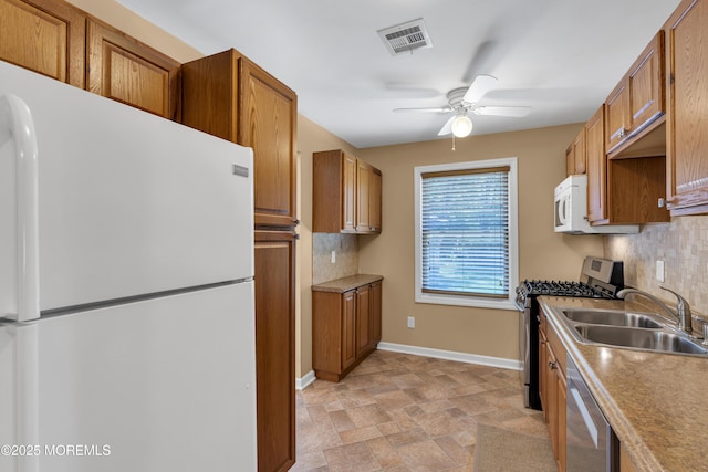 7 Juniper Ln, Jackson, NJ 08527 - kitchen with appliances with stainless steel finishes, brown cabinets, a sink, a ceiling fan, and decorative backsplash
