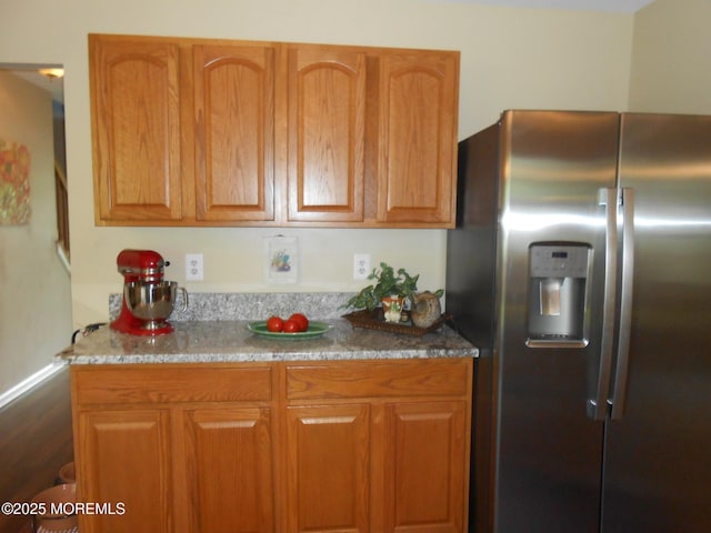 483 Coral Ln, Manahawkin, NJ 08050 - kitchen with stainless steel refrigerator with ice dispenser, light stone countertops, and brown cabinets
