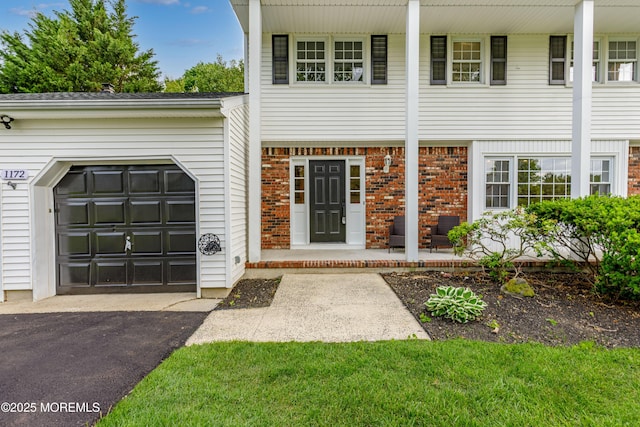 1172 Concord Dr, Brick, NJ 08724 - doorway to property featuring an attached garage, asphalt driveway, and brick siding