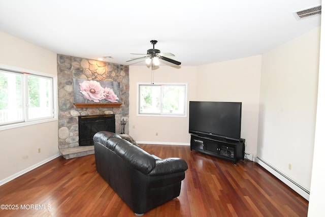 6 Marc Ln, North Hanover, NJ 08562 - living area featuring a baseboard heating unit, plenty of natural light, a stone fireplace, and a ceiling fan