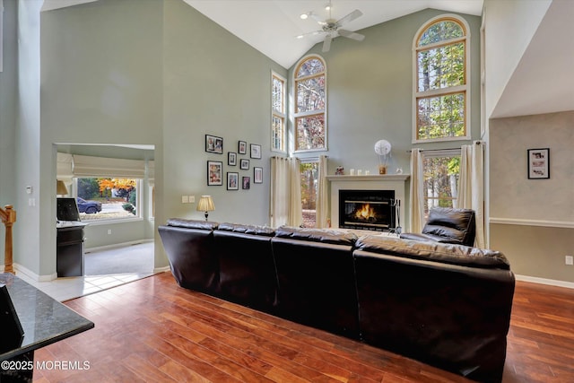 9 Rutherford Ct, Jackson, NJ 08527 - living area featuring high vaulted ceiling, a glass covered fireplace, a ceiling fan, wood finished floors, and baseboards