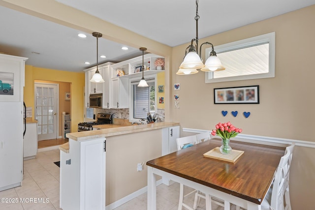 9 W Susan St, Hazlet, NJ 07730 - kitchen featuring appliances with stainless steel finishes, white cabinetry, tasteful backsplash, light tile patterned floors, and a peninsula