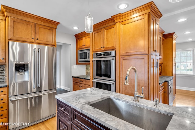6 Kenneth Dr, Ocean Twp, NJ 07712 - kitchen with stainless steel appliances, a sink, light stone countertops, baseboards, and light wood-style floors