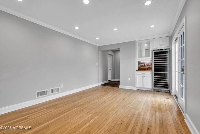 6 Kenneth Dr, Ocean Twp, NJ 07712 - unfurnished living room featuring wine cooler, crown molding, baseboards, light wood finished floors, and recessed lighting