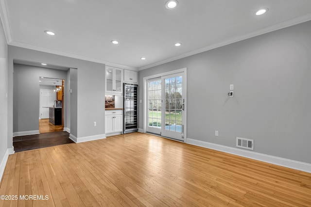6 Kenneth Dr, Ocean Twp, NJ 07712 - unfurnished living room with ornamental molding, beverage cooler, baseboards, light wood finished floors, and recessed lighting