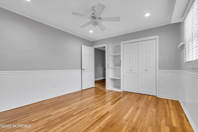 6 Kenneth Dr, Ocean Twp, NJ 07712 - unfurnished bedroom with a wainscoted wall, light wood-style floors, multiple windows, a closet, and crown molding