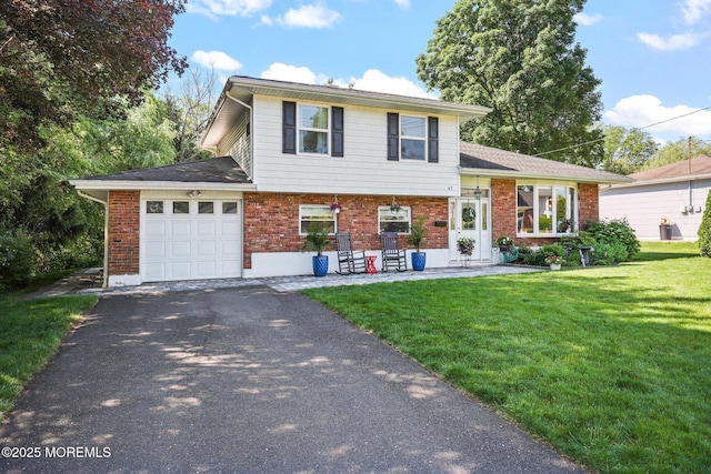 67 Koenig Ln, Freehold, NJ 07728 - tri-level home featuring a garage, brick siding, asphalt driveway, and a front lawn